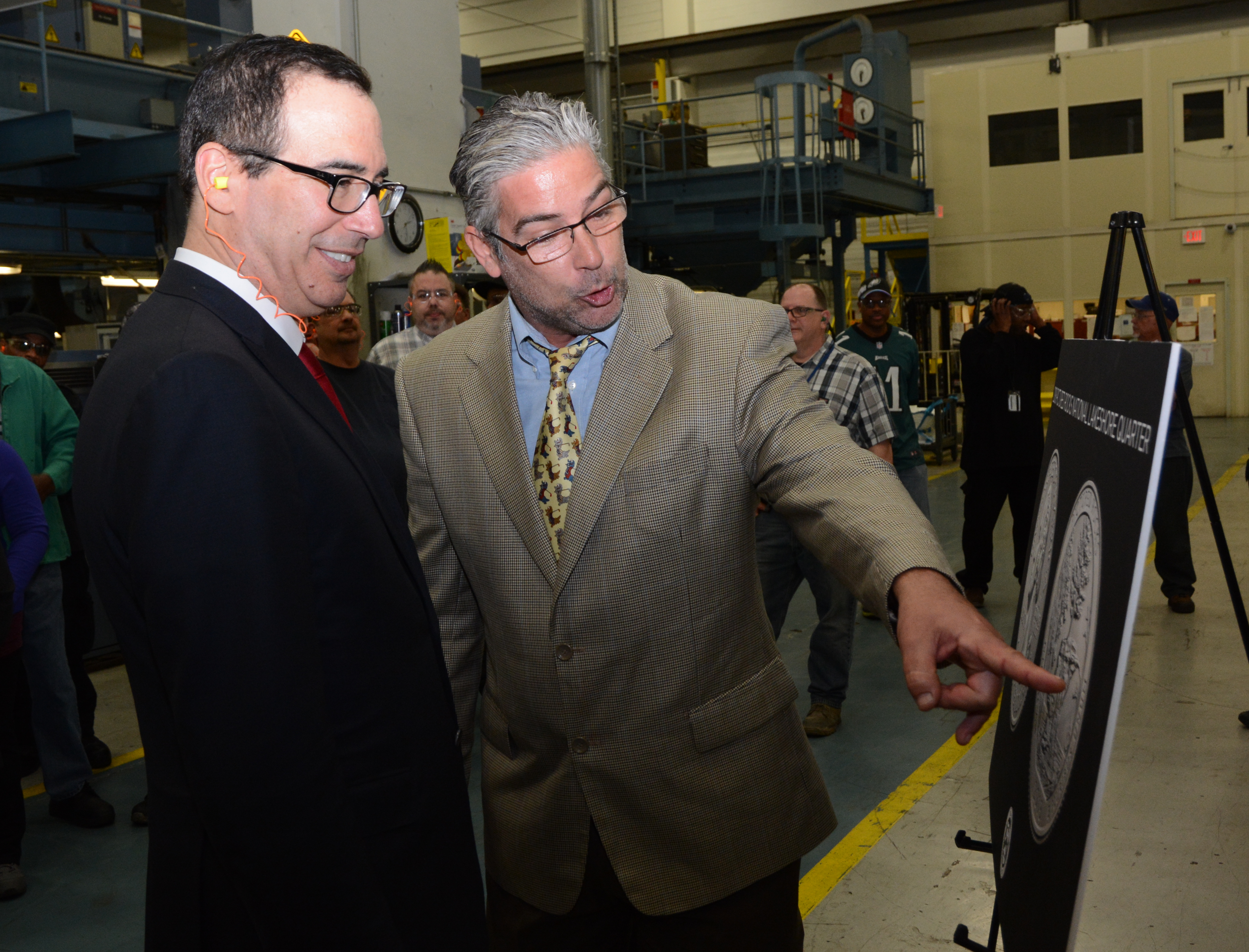 Michael Gaudioso, U.S. Mint Sculptor-Engraver of the Pictured Rocks National Lakeshore quarter, discusses his work on the coin with Treasury Secretary Steven Mnuchin during a tour of the circulating production area at the U.S. Mint facility in Philadelphi