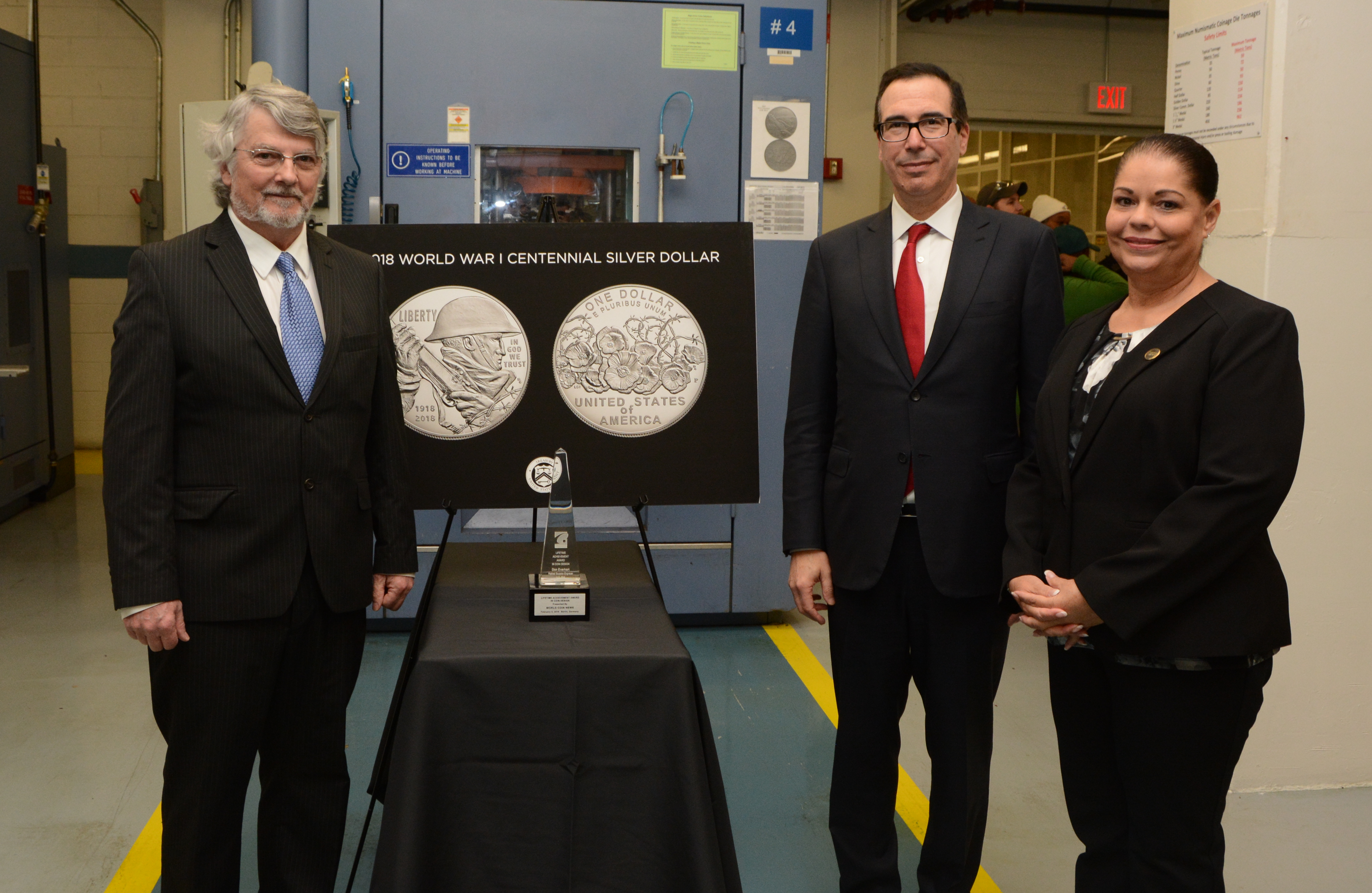 Treasury Secretary Steven Mnuchin, U.S. Mint Acting Superintendent (Philadelphia facility) Laurie Johnson, and retired U.S. Mint Sculptor-Engraver Don Everhart pose for a photo during a tour of the numismatic room at the U.S. Mint facility in Philadelphia